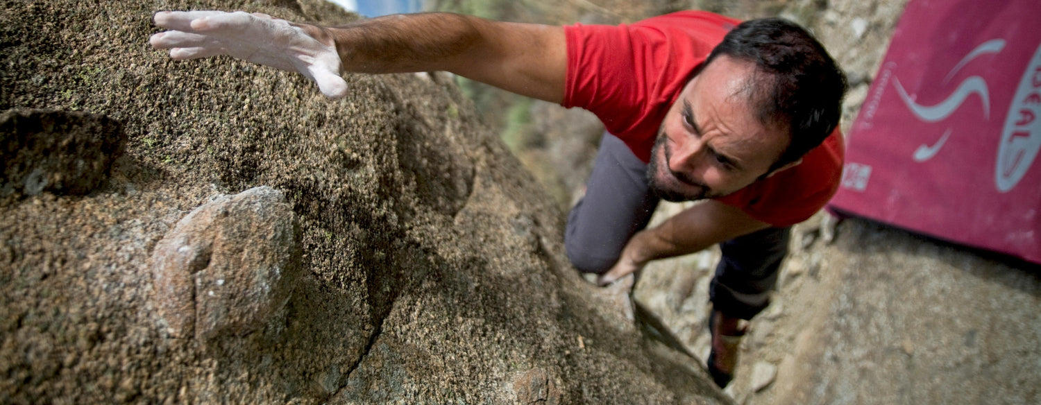 Man rock climbing, reaching upwards